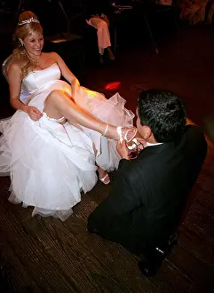 Heterosexual Prints: Groom removing garter from bride's leg