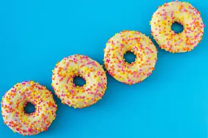 Bright Blue Prints: A group of bright motley donuts with sprinkles on blue background in abstract style