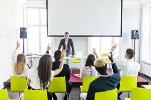 Group of business people raise hands up to agree with speaker in the meeting room seminar