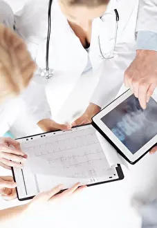 Diagnostics Prints: group of doctors looking at x-ray on tablet pc