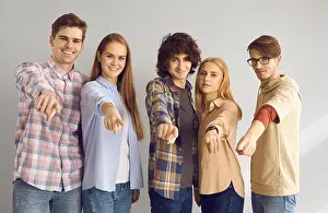 Volunteer Prints: Group of happy young people standing together and pointing at camera choosing you