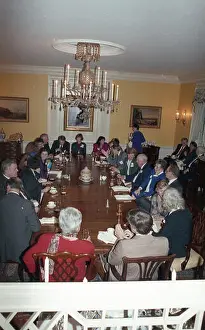 Institutional Prints: A group of people sits at a table eating during a U