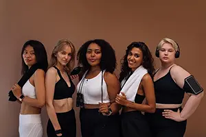 Plus Size Prints: Group portrait of a five women in sportswear standing together on brown background