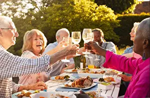 At Home Prints: Group Of Senior Friends Making A Toast At Outdoor Dinner Party