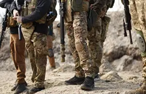 Unrecognizable Prints: Group of Ukrainian soldiers wearing multicam camouflage clothing training on shooting range with modern firearms