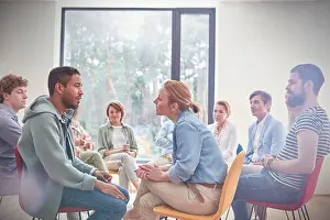Three Quarter Length Prints: Group watching man and woman talking face to face in group therapy session