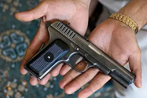 A gun seller holding a copy of a Soviet gun in Darra Adam Khel Pakistan