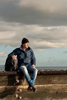 Getting Away From It All Prints: Guy with a backpack sitting resting enjoying the view after walking