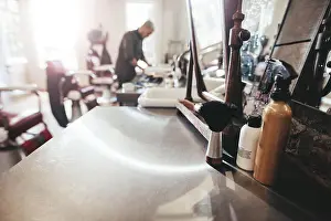 Mens Prints: Hairdresser tools on counter with barber in background