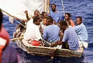Cuban Prints: Haitian refugees watch from their crowded sailboat as a U