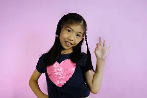Accept Prints: A half body shot of a cute young Asian girl