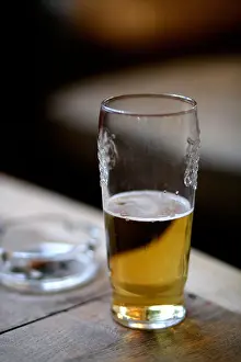 Swallow Prints: Half drunk pint of beer in a pub with an ashtray