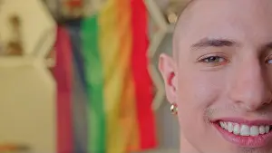 Lgbt Prints: Half face of smiling caucasian man with LGBT flag in the background. High quality photo