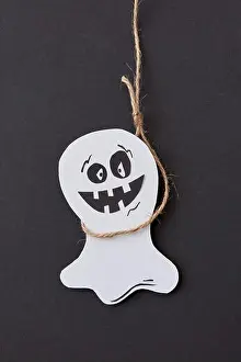 Handcraft Prints: Halloween greeting card with laughing flying scary Casper hanging from a rope handmade from paper on a black