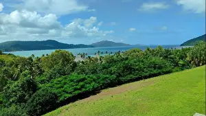 Tropical Paradise Prints: Hamilton Island panorama: lush green hills roll down to a turquoise ocean