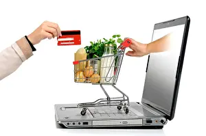 Checkout Prints: Hand with credit card and a small shopping cart coming from laptop screen isolated in white