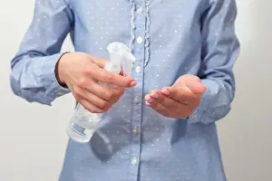 Hygienic Prints: Hand disinfection. Lady's hand takes alcohol disinfectant spray on her hands