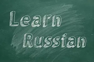 Understand Prints: Hand drawing 'Learn Russian' on green chalkboard