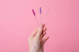 Mascara Prints: Hand with eyelash wands, brushes for separating lashes after applying mascara