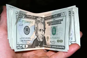 Handful Prints: Hand holding USA twenty dollar bills on black