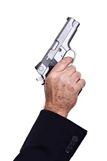 Alertness Prints: The hand mature adult man wearing suit holding 9mm gun his right hand aiming it diagonallyupwards