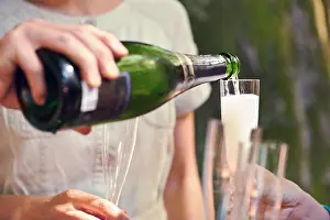 Multicultural Prints: Hand, pour champagne and glasses for group of friends for celebration