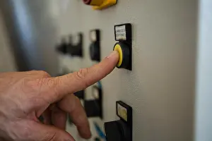 Creating Prints: Hand pressing a control button in factory