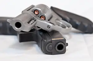 Defend Prints: Two handguns, a silver 357 magnum revolver on top of a black 9mm pistol on a white background