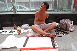 Handicapped Prints: The handicapped Chinese man without hands uses his toes to write calligraphy of 'Zi Qiang Bu Xi'