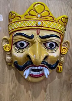 West Bengal Prints: Handmade colorful tribal look of Ravan face mask souvenir hanging on plain black background