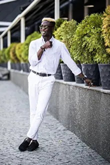 Direct Prints: Handsome Afro American business man wearing stylish clothes in modern city sits near the building