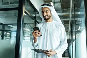 White Work Prints: handsome man with dish dasha working in his business office of Dubai