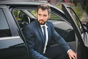 Opened Prints: Handsome man in suit getting out of car