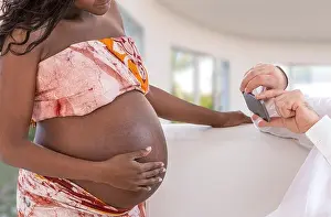 Handsome man takes photos with smartphone of young happy pregnant woman living room