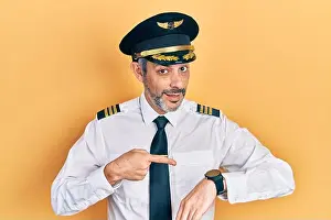 Hurry Prints: Handsome middle age man with grey hair wearing airplane pilot uniform in hurry pointing to watch time