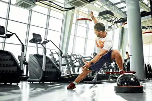 Bodybuilding Prints: Handsome muscular men works out on functional training soft platform on a background of gym
