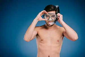 Snorkel Prints: handsome shirtless young man in snorkel and scuba mask looking at camera on blue