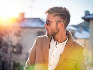 Good Looking Prints: Handsome trendy blond man standing outdoor in European city setting with elegant old historic building behind
