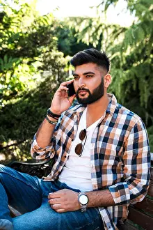 Satisfied Prints: Handsome young indian man using mobile phone