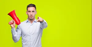 Megaphone Prints: Handsome young man holding microphone pointing with finger to the camera and to you