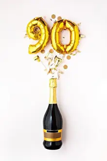 Happy 90th anniversary party. Champagne bottle with gold number balloon