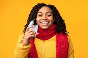 Take Off Prints: Happy African Lady Taking Off Protective Face Mask, Yellow Background