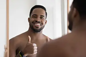 Lotion Prints: Happy attractive young African man looking and smiling at camera