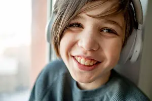 Toothy Smile Prints: Happy boy listening to music through wireless headphones