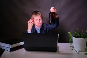 Preteen Prints: A happy boy in a school suit with a bottle of alcohol in his hands