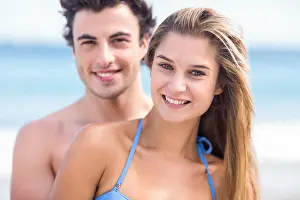 Toned Prints: Happy couple in swimsuit looking at camera and embracing
