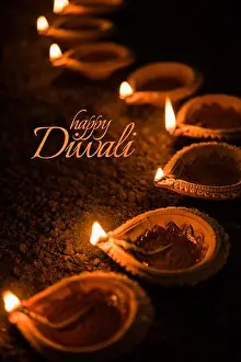 Deepawali Prints: Happy Diwali greeting card design using Beautiful Clay diya lamps lit on diwali night Celebration
