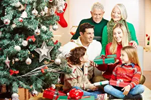Gifts Prints: Happy family with three generations celebrating christmas with gifts