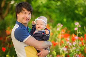 Cuddling Prints: Happy father and child playing together on the poppy meadow