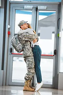 Professional Occupation Prints: happy girlfriend hugging cheerful boyfriend in military uniform in airport